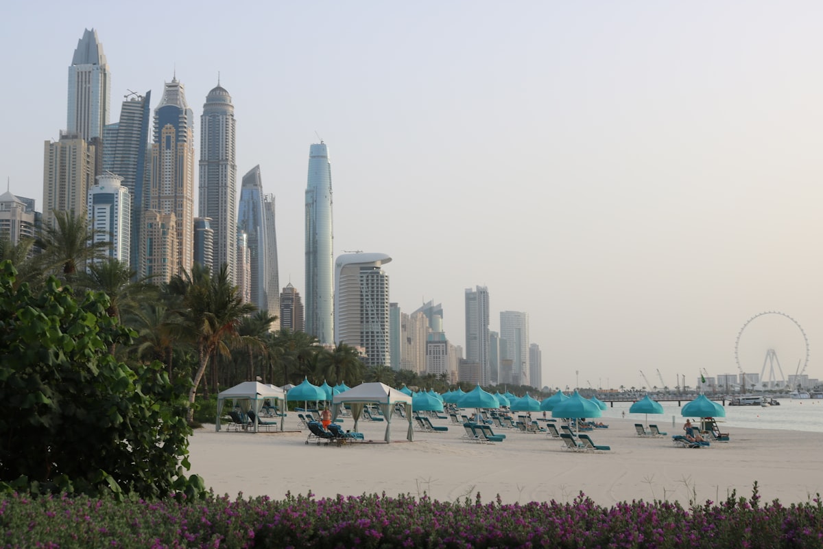 Dubai beach with lounge chairs, umbrellas, and Marina skyline